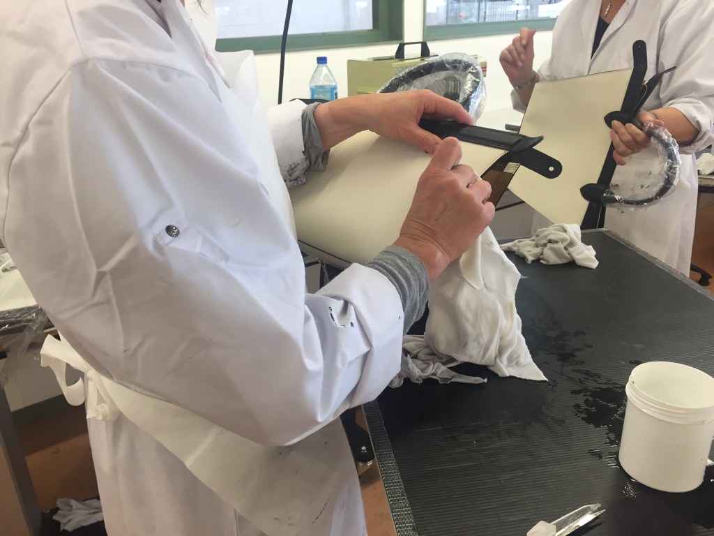 Des ouvrières teignent les coutures du "it bag" Pliage Héritage. Jusqu'à neuf passages sont nécessaires